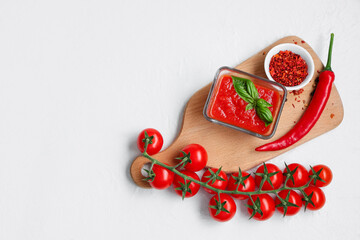 Wall Mural - Glass bowl of tomato sauce with basil and chili pepper on white background