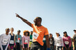 © Jacob Lund - Group of diverse runners celebrating at outdoor marathon finish