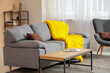 © Pixel-Shot - Modern interior of living room with stylish sofa, table and yellow knitted plaid