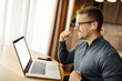 © Dusan Petkovic - Cheerful freelancer sitting at cozy home and celebrating success while smiling at laptop.