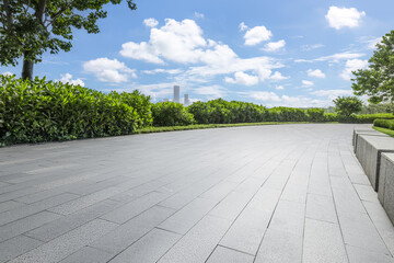 Wall Mural - Empty pavement floor with city skyline and green park