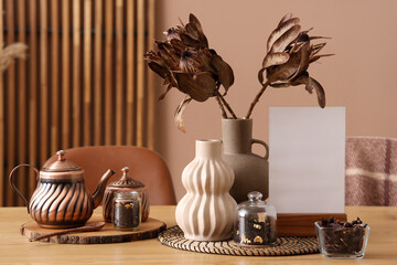 Wall Mural - Vases with dried flowers, blank frame and tea on dining table in room