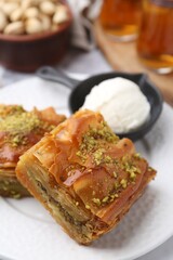 Canvas Print - Delicious baklava with crushed nuts and ice cream on table, closeup