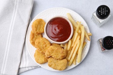 Sticker - Tasty chicken nuggets and french fries with sauce on light table, flat lay