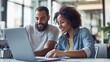 © Ruslan - Two coworkers, a man and a woman, collaborate on a laptop. They're focused and smiling in a modern office setting.