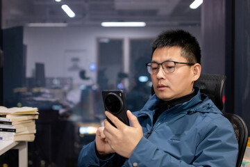 asian man using smart phone in office