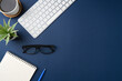 © yalcinsonat - Workspace with keyboard, laptop, office supplies, pen, green leaf and coffee cup. Flat lay, top view blue office desk