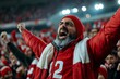 © Jane_S - Excited middle-eastern mature male football fan cheering in stadium
