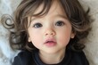 © Luismartin_fit - Close-up portrait of a young child with big expressive eyes, symbolizing innocence and curiosity.