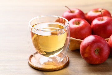 Wall Mural - Glass of apple cider and red apple fruit on wooden background