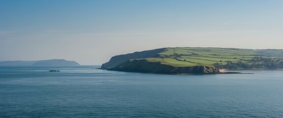 Wall Mural - Scenic Coastal View Over Calm Waters Featuring Lush Green Headland and Clear Blue Skies Ideal for Text Overlay or Branding