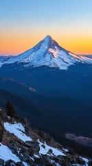 Wall Mural - Snow-capped mountain peak at sunset with vibrant sky and rocky foreground. Dramatic nature scenery, wilderness and exploration concept