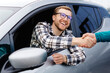 © nazariykarkhut - Man buying car and shaking hands with salesman against blurred auto, closeup. Concept of choosing and buying new car at showroom