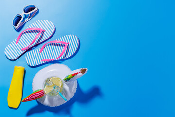 Poster - A vibrant summer vacation scene with flip flops, shades, and a floating flamingo with cocktail