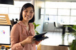 © Wavebreak Media - Smiling businesswoman using tablet in modern office with bright natural light, copy space