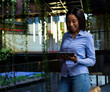 © Wavebreak Media - Smiling woman using tablet in modern office with greenery and lights, copy space