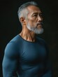 © Jaemie - Dynamic Fashion Portrait of a Mature Man in a Fitted Blue Shirt Against a Dark Background, Ideal for Fitness Lifestyle Marketing