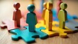 © Viktor - Colorful wooden figures represent diverse people connecting on jigsaw pieces. Teamwork, diversity concept visualizes HR strategies for inclusive workplace cultures, talent management. Different