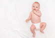© Ирина Гутыряк - cute baby in diaper lying on back, smiling and holding hand in mouth