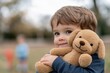 © Milos - A cheerful child smiles gently while embracing a soft toy dog in a serene outdoor environment, showcasing innocence and warmth associated with childhood playfulness.