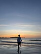 © Lucas - Person walking on the beach at sunset