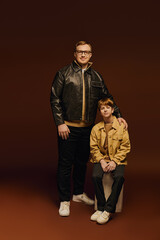 Wall Mural - Father and son share a joyful moment in stylish outfits during a studio session