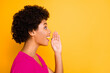 © deagreez - Photo of pretty wavy dark skin lady sharing new information with people holding arm near mouth wear orange t-shirt isolated yellow color background