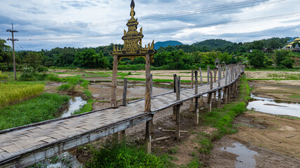 Wall Mural - Aerial view Amazing beauty in the hill tribe village.The bridge snaking through the rice fields to link the clergy and the community is one of Mae Hong Son's longest and most beautiful bamboo bridges