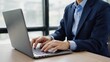 © Danudet.C - Business Professional Typing on Laptop in Modern Office Environment
