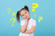 © New Africa - Confused little girl on light blue background. Yellow question marks near child