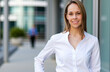 © Minerva Studio - Portrait of smiling businesswoman standing outside office building