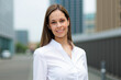 © Minerva Studio - Smiling businesswoman standing in the financial district