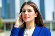 © Minerva Studio - Businesswoman touching face while thinking in city center