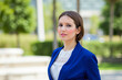 © Minerva Studio - Businesswoman posing outdoors in a park wearing a blue blazer