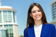 © Minerva Studio - Smiling businesswoman standing in front of office buildings