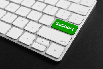 Technical support. Computer keyboard with word on green button, closeup