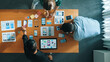 © Summit Art Creations - Top view of smart Ui designer brainstorming and planning about Ux Uo design or mobile interface wireframe design with diverse develop team. Caucasian programer walking and joining meeting.Convocation.