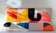 © Galina - Artistic modern quilt featuring vibrant geometric patterns and bold colors arranged on a minimalist white surface, softly illuminated by natural light,
