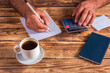 © Armine - Person using a calculator to calculate income and result