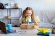 © Prostock-studio - Doing Homework. Portrait of charming teenage girl reading paper book, sitting at desk, copy space