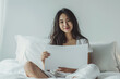© ExF Designs - Asian Woman in Bedroom Holding Blank Paper on White Bed. Mockup with Room for Text.