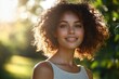© app - Outdoor Portrait of a Cheerful Woman with Curly Hair Smiling in a Green Park During Golden Hour