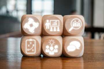 Wall Mural - wooden blocks with business icons symbolizing strategy, teamwork, and communication on a wooden tabl