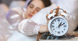 © Pixel-Shot - Young woman turning off alarm clock in bedroom, closeup