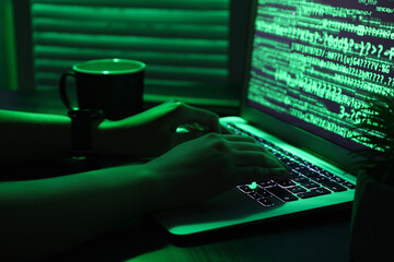 Wall Mural - female programmer typing on laptop keyboard at night in office, closeup