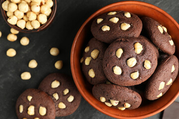 Wall Mural - Tasty chocolate cookies with hazelnuts on black table, flat lay