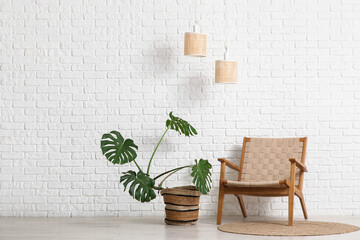 Canvas Print - Monstera houseplant and armchair near white brick wall in room