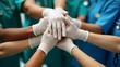 © snupdo - A Close-Up of Hands of Different Ethnicities Stacking Together, Wearing Medical Gloves and Scrubs, Representing Trust and Teamwork