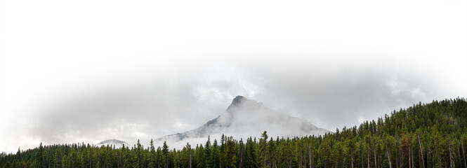 Wall Mural - Panorama of a pyramid shaped mountain in the clouds with a forest in the foreground and a partially transparent sky
