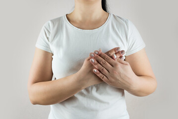 woman in white t-shirt suffers from heart pain. Heart pain.